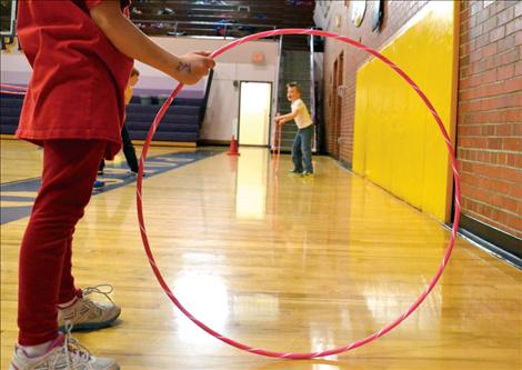 Holden Love, right, invented a hula-hoop game he named “Catch and Tackle,” with Ellie Dupuis, center, and Quinton Clark. The object of the game is to tackle two hula-hoops with the roll of a third. Love said he loves to play football.