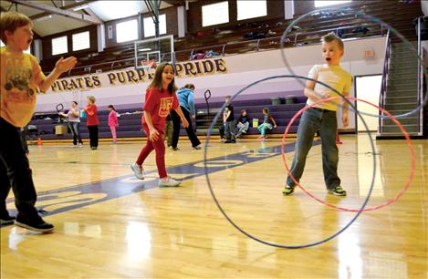 Holden Love, right, invented a hula-hoop game he named “Catch and Tackle,” with Ellie Dupuis, center, and Quinton Clark. The object of the game is to tackle two hula-hoops with the roll of a third. Love said he loves to play football.