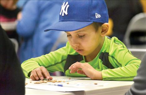 Surrounded by family, Cole Whitworth carefully studies his bingo card