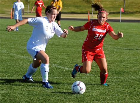 Polson junior Amanda Harrod tries to get away from a Loyola player during Thursday’s game in Polson.