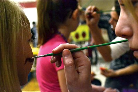 Students facepaint to raise funds for their class.