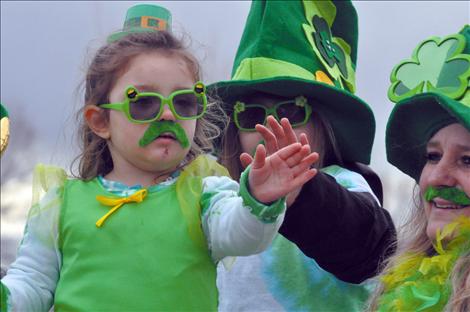 Tomee Herzog waves from her parade float as it travels down Main Street on St. Patrick's Day.