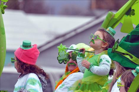 Tomee Herzog waves from her parade float as it travels down Main Street on St. Patrick's Day.