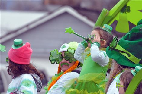 Tomee Herzog waves from her parade float as it travels down Main Street on St. Patrick's Day.