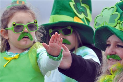 Tomee Herzog waves from her parade float as it travels down Main Street on St. Patrick's Day.