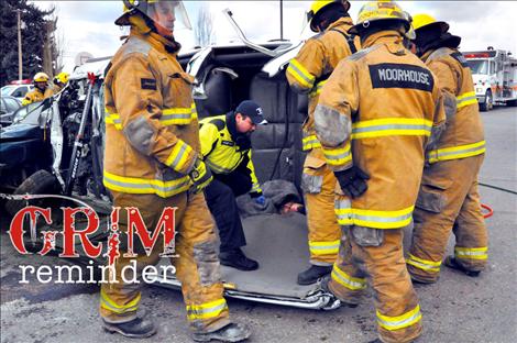 Ronan volunteer firefighters attempt to rescue Ronan High School Principal Kevin Kenelty during a mock fatal drunken driving wreck staged at Ronan High School.