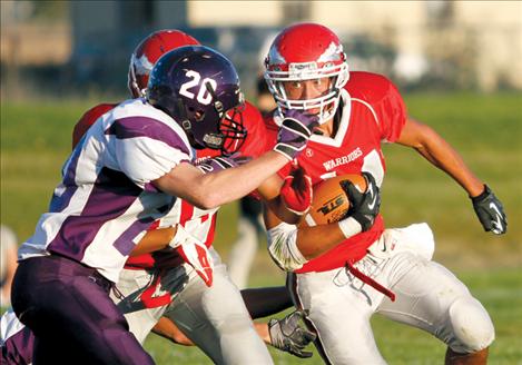 Arlee senior running back Christian Haynes dodges Charlo defender Tyler Delaney early in Friday’s Western C matchup in Arlee. Charlo won, 49-6.