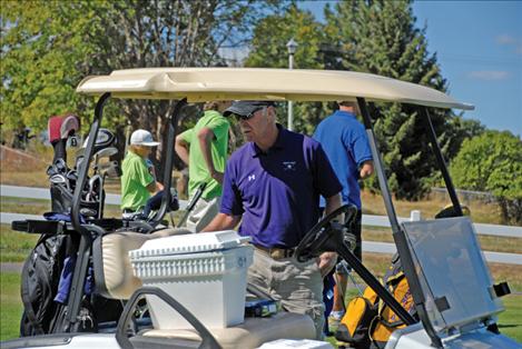 Bill Owen, head coach of the Polson High School Golf Team, checks his cart to make sure it’s stocked with water, scorecards and pencils before he heads out to check on young golfers.