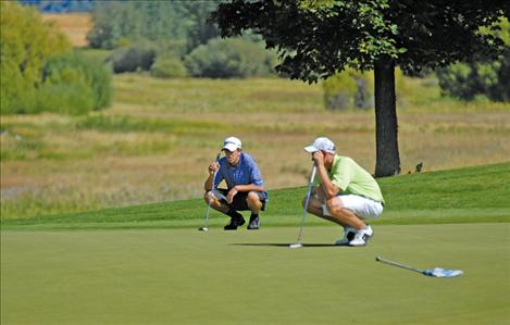 PHS golfer Hayden Congdon, left, and a Whitefish High School golfer check out the way the green lies before they put on hole seven of the Polson Bay Golf Course. Congdon scored an 83 at the tournament. 