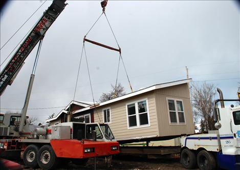 A crane drops half of Lucky and Barbara Donegan’s house into place in Polson.