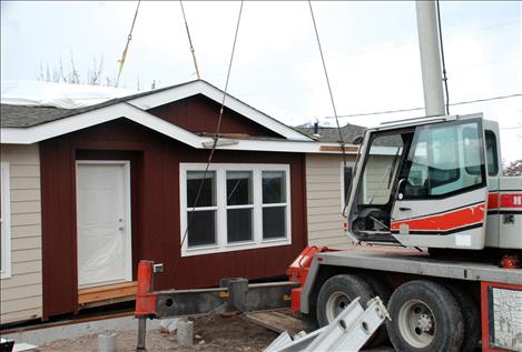 A crane drops half of Lucky and Barbara Donegan’s house into place in Polson.