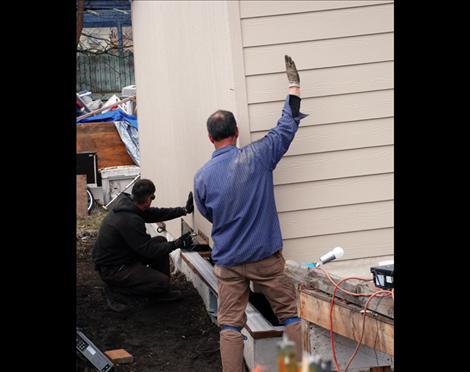 Workers lower Lucky and Barbara Donegan’s house into place in Polson.