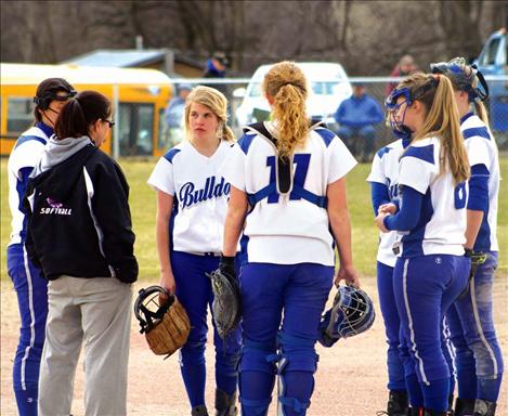 MAC players come in for a conference with their coach mid-inning.