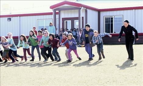 Lt. Governor Angela McLean plays a game of run and scream with Arlee schoolchildren.