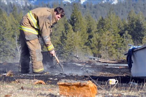 Ronan volunteer firefighter James Bays smothers hot spots left from a March 31 private burn in Ronan that grew out of control when the wind picked up.