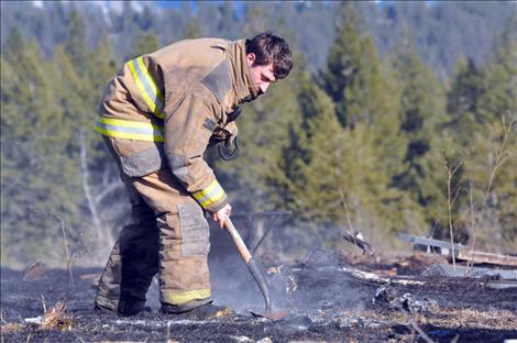 Ronan volunteer firefighter James Bays smothers hot spots left from a March 31 private burn in Ronan that grew out of control when the wind picked up.