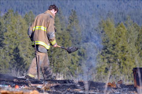 Ronan volunteer firefighter James Bays smothers hot spots left from a March 31 private burn in Ronan that grew out of control when the wind picked up.