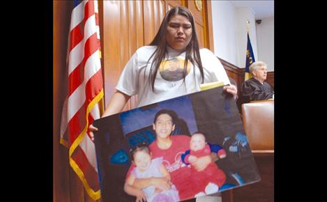 Kayla Ridgley leaves the witness stand with a photo of her cousin Laurence Kenmille and two of his children.