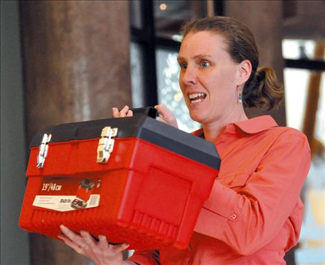 Heidi Sedivy shows the Flathead Basin Commission a speaker’s toolbox of visual aids that can be used to educate the public about invasive species. 