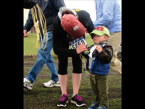 Aaron Naugle, 2, gets a medal for finishing the one-mile race. 