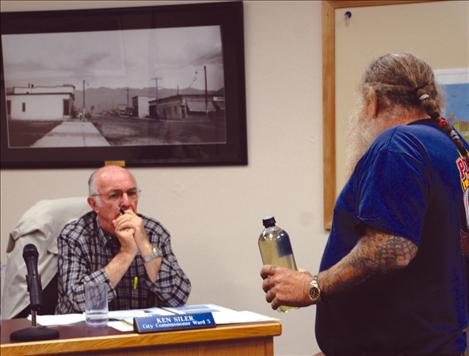 Polson City Commissioner Ken Siler listens as Tony Porrazzo explains the need for a new wastewater facility.