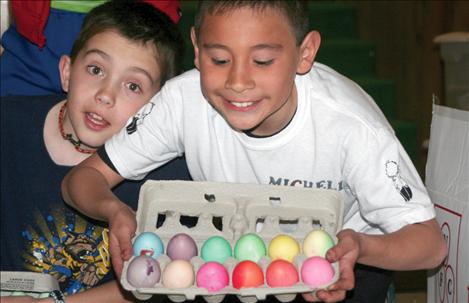 St. Ignatius cub scouts Landry Leishman and David Michell hold a carton of colorful eggs.