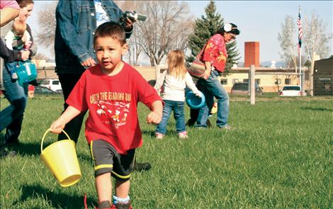 Mikey McCrea, 3, leads the pack collecting eggs in St. Ignatius.