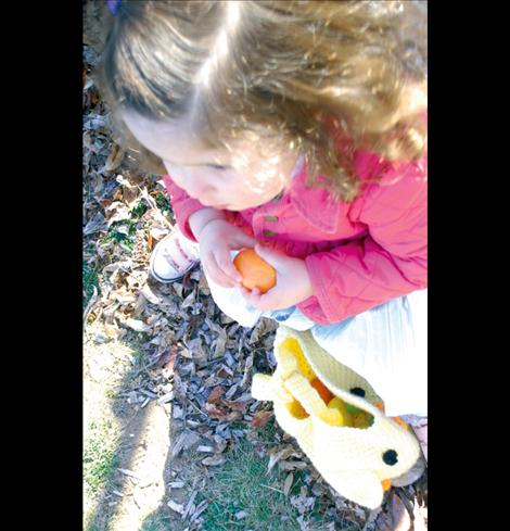 EmiMae Yamada-Morigeau cracks a plastic Easter egg to see what’s inside.  