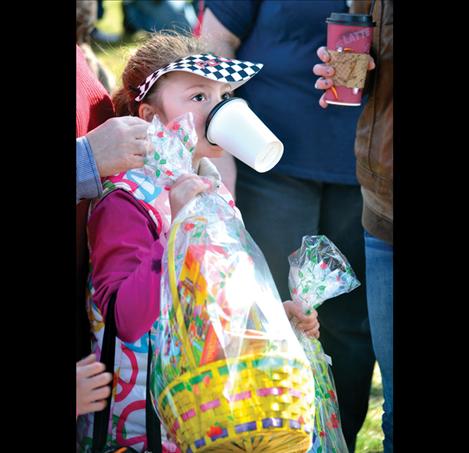 Kaydynce Dunkerson, 7, juggles a paper mug and two Easter baskets she won at Ronan’s egg hunt