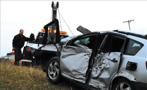 Chris Adler from Draggin’ Wagon Towing of Ronan begins pulling the Pontiac Vibe away from a tree the car smashed into several days earlier.