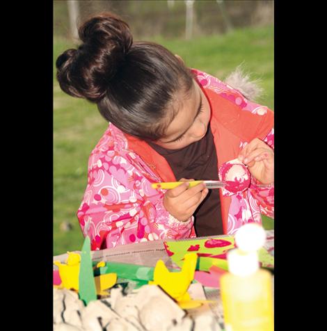 Maleea Stewart paints flowers from recycled paper.