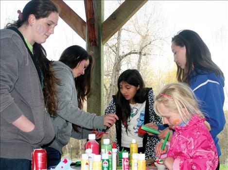 Trish Corbitt, 8, paints a recycled paper daffodil with the help of SSC members. 