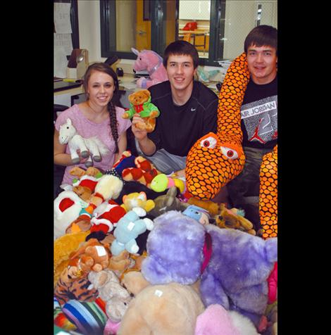 High School National Honor Society students Alexis Shick, Josh Reed and Zane Ligas work at sorting the stuffed animals to make it easier for emergency responders to carry them in their vehicles and distribute to children.