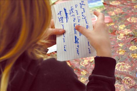 A girl folds an index card of questions about careers at K. William Harvey Elementary School. 