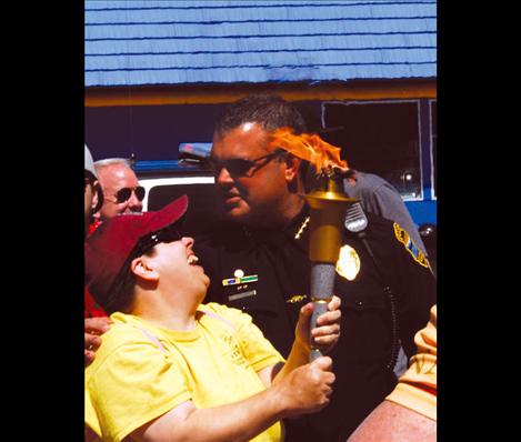 A Special Olympian holds the torch as she stands next to Polson Police Chief Wade Nash.