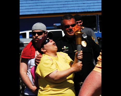 A Special Olympian holds the torch as she stands next to Polson Police Chief Wade Nash.