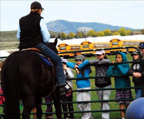 Jane Clapp and her horse, Smokey, demonstrate horse training maneuvers for fourth-grade students.