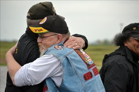 John Burgess gets a hug from veteran Chuck Lewis before Burgess led the group out of Ronan and onto a healing, cross-country trek.