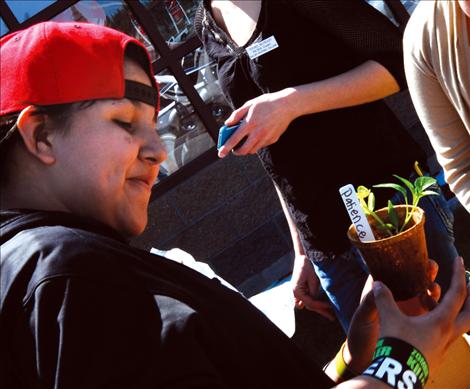 Patience Alexander pots vegetable starts and receives a pepper plant to take home and plant. 