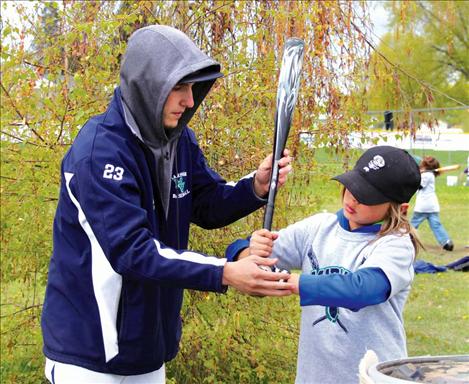 Mission Valley Mariner Ryan Pablo teaches Elijah Cummings how to hold a bat.