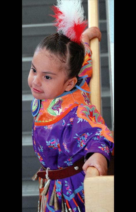 Audrey Kenmille plays on the stairs, waiting for the powwow to begin.