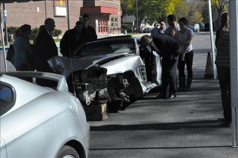 The family and legal counsel of two teenagers killed in a 2011 Arlee wreck view what is left of a Hyundai Tiburon. The crashed car was parked next to an undamaged version of the same vehicle as a visual aid for the jury. 