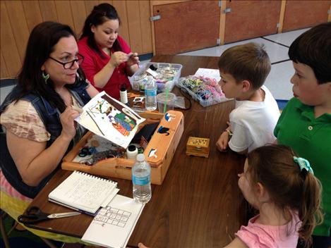  Super beader Dana Hewankorn shows  Cherry Valley students and siblings a beaded painting she is making during Cherry Valley’s Night of the Arts. 