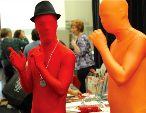 Mr. Red and Mr. Orange walk through the crowds at Women 4 Wellness, raising HIV awareness.