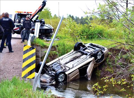 A wrecker pulls the car from the irrigation canal off Canyon Mill Road Monday morning in Ronan. Two Ronan women died in the wreck.