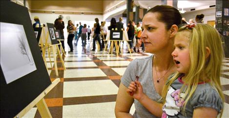 Carrie Robbins discusses photographs with daughter Rosalee, 4.