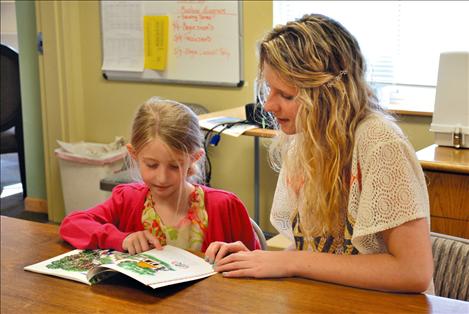 Gracie Larivee, 6, reads a story with graduating Mission Valley Christian Academy senior Abby Lake.
