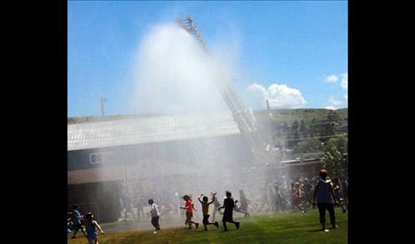 The Polson Fire Department provides some welcome water for Linderman kids on a warm day.
