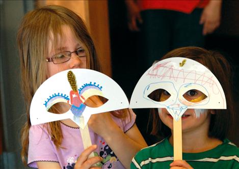 Sofia Leighton-Pahlen, left, and Kena Sutton model their bird masks.