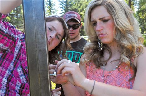 Ronan student Laurel Rigby helps set up a sign made by her vo-ag class.  